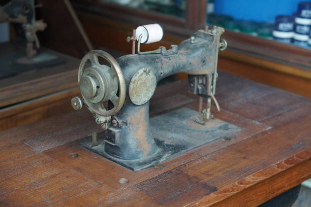 istock side view antique and dirty black and brown sewing machine on wooden sewing machine table, spool of white thread, object, technology, work, decor, copy space 2184223322