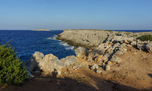 istock A serene coastal view with rocky cliffs and azure waters on a clear day at sunset. 2184225456