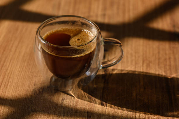 istock A rich espresso served in a double-walled glass cup resting on a rustic wooden table caught in soft morning light 2184225511