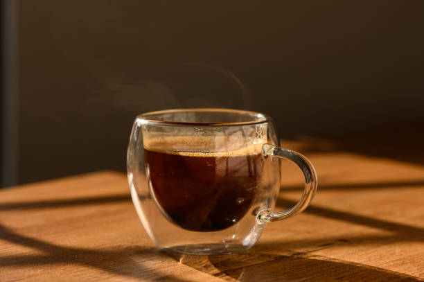istock A steaming cup of coffee rests on a wooden table bathed in warm sunlight 2184225513