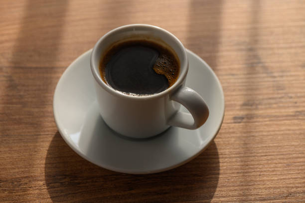istock A steaming cup of coffee on a wooden table with morning light streaming in 2184225521