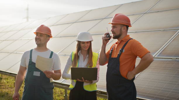 istock Footage with solar energy station, Director and workers communicating discussing technical aspects, director holding photovoltaic item in hand. Solar park. Clean energy. Alternative energy concept. 2184225565