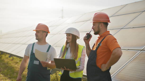 istock Footage with solar energy station, Director and workers communicating discussing technical aspects, director holding photovoltaic item in hand. Solar park. Clean energy. Alternative energy concept. 2184225617