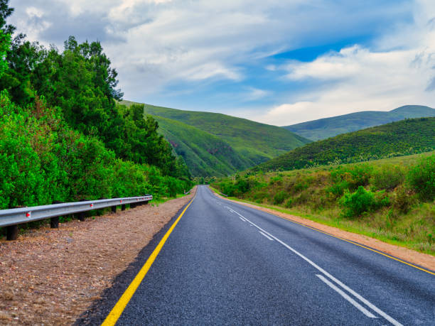 istock Road winding through rolling hills and mountains under blue sky with white clouds, Suurbraak, Western Cape, South Africa 2184225951