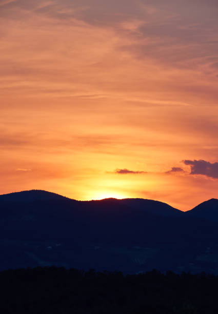 Picturesque silhouette mountain ranges and landscape against idyllic orange sky during sunrise at Avaigliano Umbro, Umbria, Italy