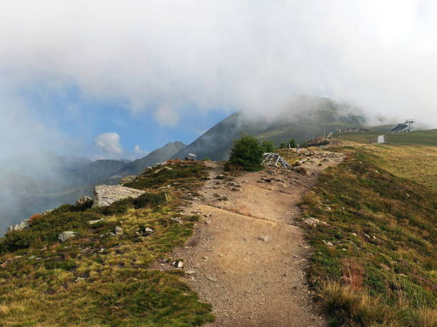 istock Hiking path through misty mountains with lush greenery on a clear day 2184228490