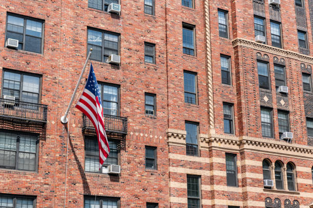 istock architectural exterior and facade. new york city architecture. brownstone building architecture of new york. american flag on brick brownstone building. office building 2184228564