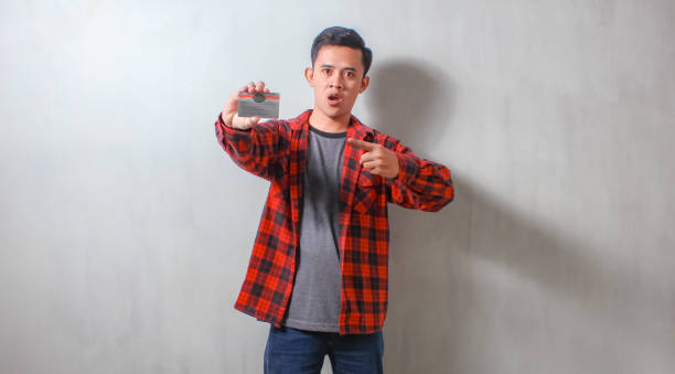 istock Asian man shows driver's license isolated white background 2184229007