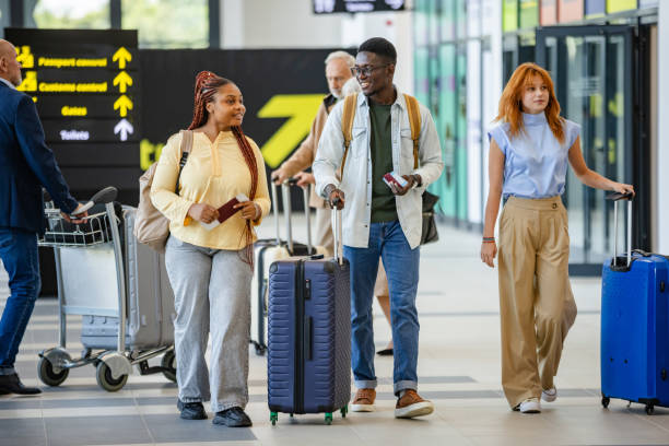 istock Diverse travelers navigate terminal with check-in bags. 2184229289