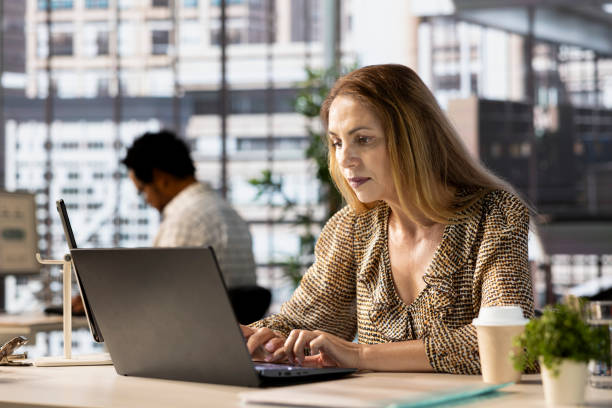 istock Female executive reviewing business operations at her desk 2184229616