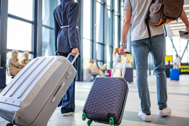 istock Elegant travelers walking through airport interior. 2184230891