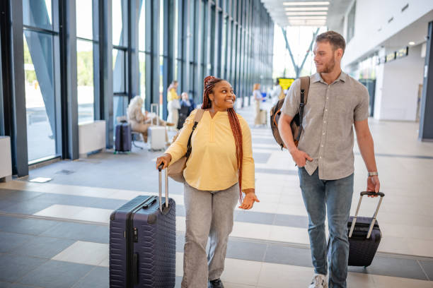 istock Happy travelers with luggage at spacious terminal 2184232557