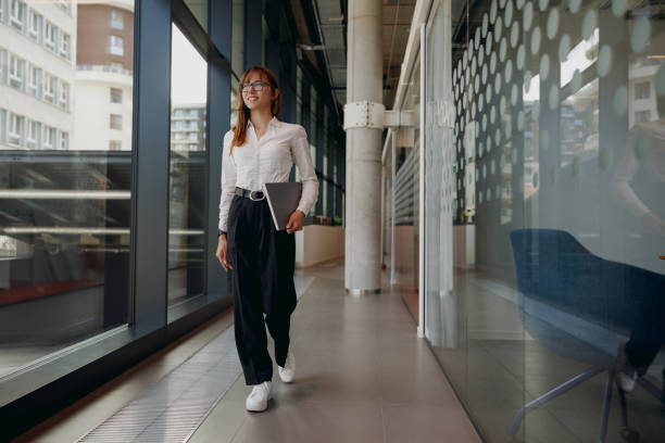 istock A Professional Woman Confidently Walking Through a Modern Office Space Designed for Productivity 2184234395