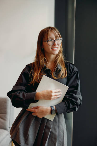 istock A Confident Woman Dressed in Professional Attire is Holding a Notebook in Her Hands 2184234647