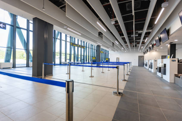 istock Modern airport check-in area with blue barriers and signs 2184235480