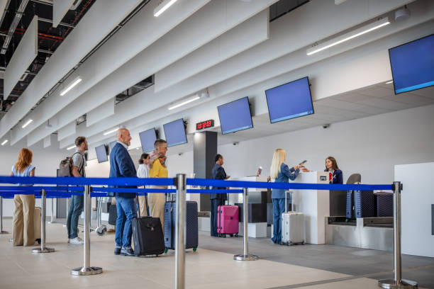 istock Passengers queuing at airport check-in with baggage. 2184235846