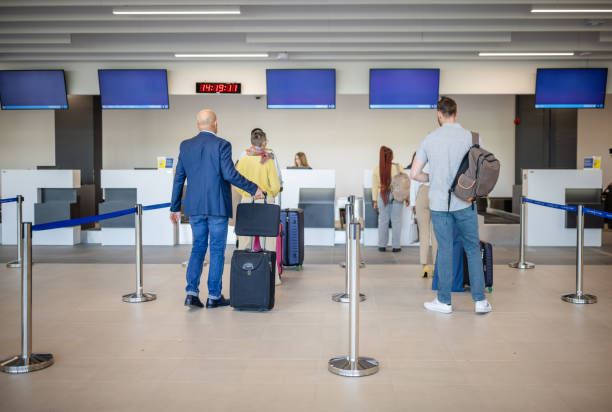 istock Passengers standing in line at airport check-in counters. 2184235879