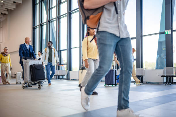 istock Passengers strolling with luggage in airport lobby 2184235904