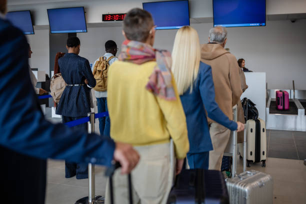 istock People waiting in line at airport check-in counter. 2184236089