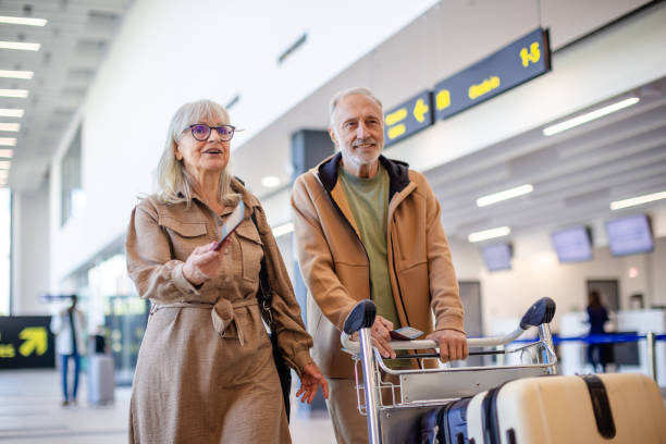 istock Senior couple navigating airport with luggage, smiling 2184237113