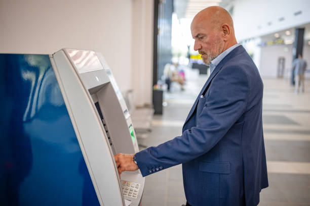 istock Senior man at ticket kiosk preparing for travel 2184237176
