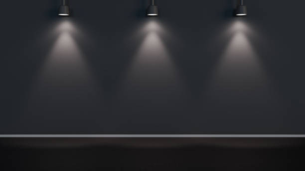 istock Three spotlights illuminating a black wall in a minimalist studio 2184237325