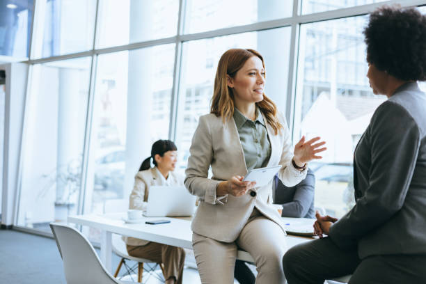 istock Businesswoman in conversation with colleague 2184237555