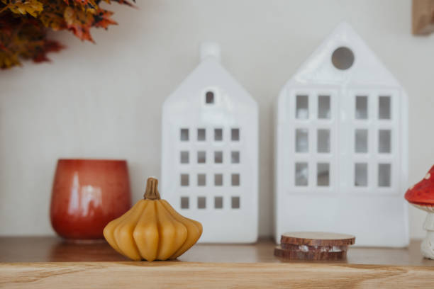 istock Autumn decor featuring small pumpkin and white house lanterns on wooden table 2184238071