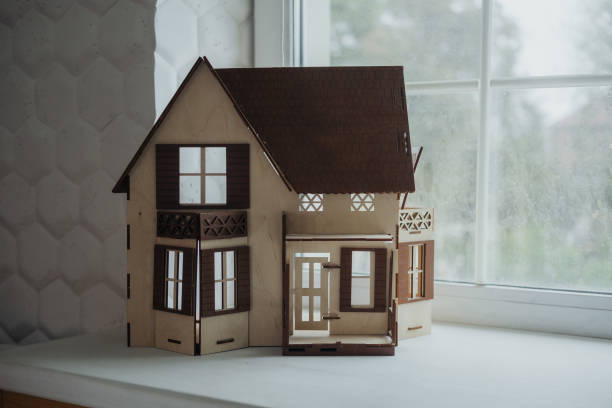 istock A model wooden house displayed on a windowsill with natural light in a cozy interior setting 2184238173