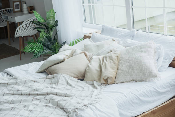 istock A stylish bedroom featuring a spacious bed with various soft pillows and a soothing blanket 2184238180