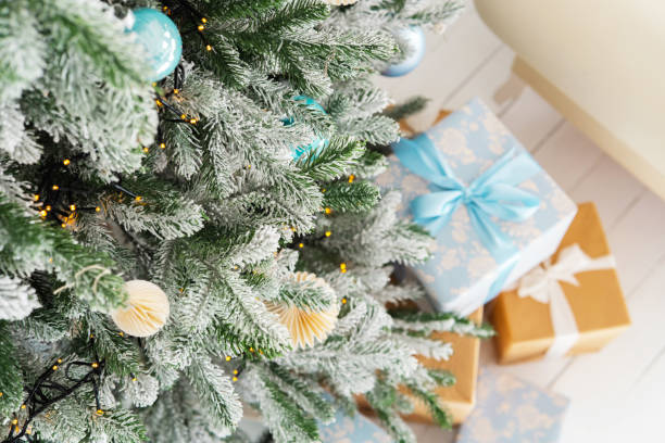 istock Decorated Christmas tree with gifts under it in a cozy living room setting 2184238341