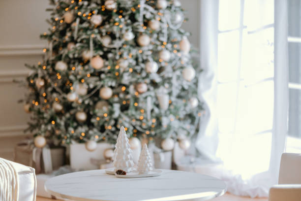 istock Christmas tree decorated with white ornaments and snow-covered trees indoors 2184239853