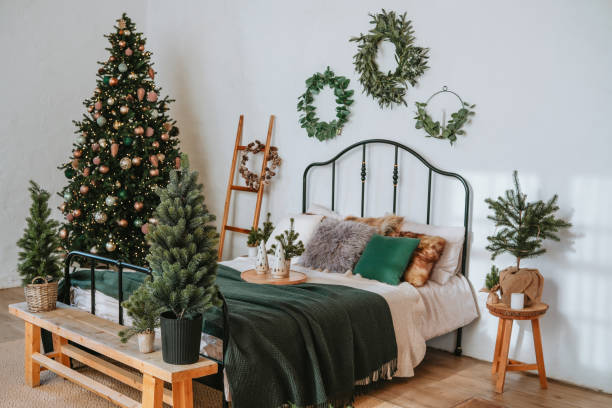istock Cozy bedroom decorated for Christmas with a festive tree and greenery accents 2184239937