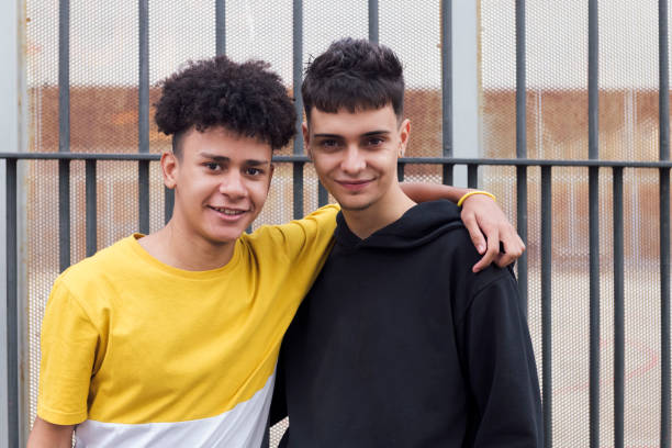 istock smiling latin man hugging teen friend 2184240821