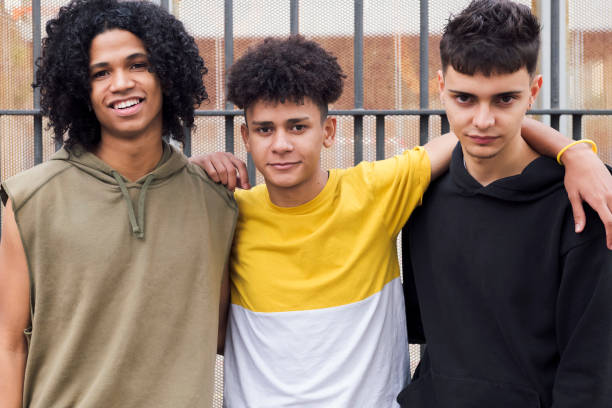 istock three teen friends hugging looking at camera 2184240824