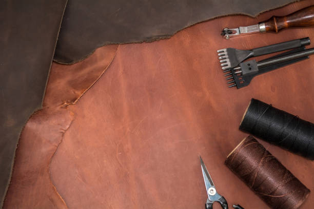 istock Pieces of natural calf leather and tools for leather processing. A leather craftsman's workshop. 2184241122