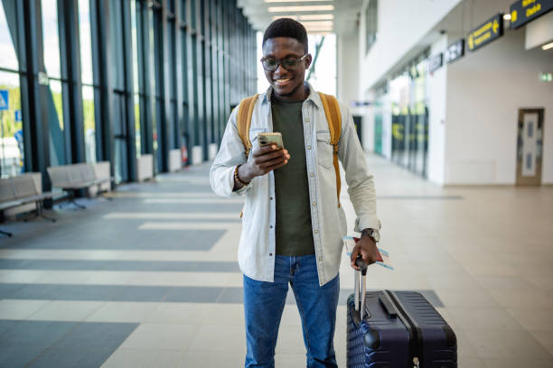 istock Traveler looking at smartphone in sunlit terminal. 2184241436