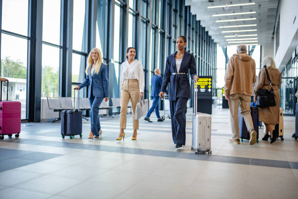 istock Businesswomen Striding Through Modern Airport Hall 2184249080