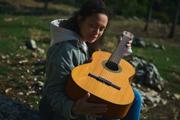 istock Woman enjoying a peaceful moment outdoors with her guitar 2184252205