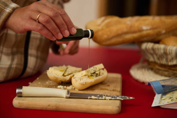 istock Close-up of hands preparing bread with olive oil and herbs 2184252237