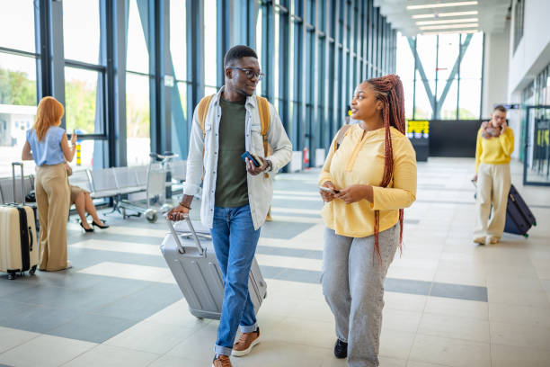 istock Travelers walking through a spacious airport hallway. 2184253661