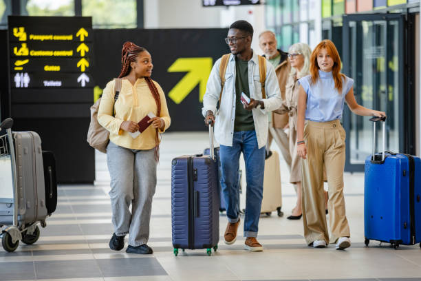 istock Travelers, including seniors, move through airport hall. 2184254996