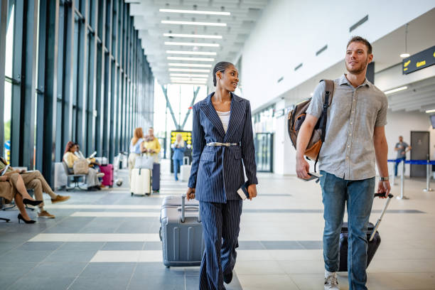 istock Two travelers walking in modern airport terminal. 2184256253
