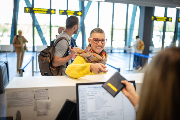 istock Woman checking in at airport counter smiling bright 2184258337