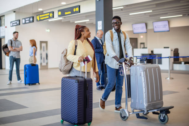 istock Young couple with baggage walking through airport 2184261400