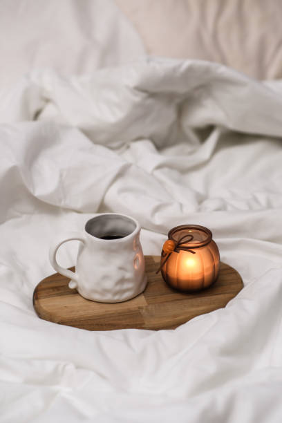 istock Wooden tray with coffee and interior decor on the bed with white linen 2184263784