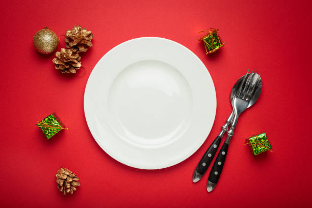 istock Christmas table setting decorated with empty plate, golden pine cones, and gift boxes 2184264226