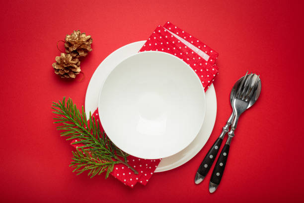 istock Christmas table setting decorated with pine cones and fir branches on red background 2184264249