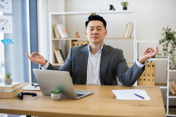 istock Businessman practicing meditation for stress relief in office 2184270246