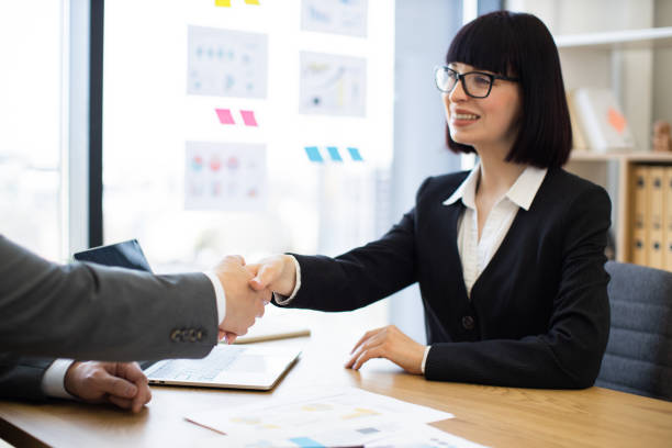 istock Businesswoman shaking hands in office setting for successful agreement 2184270334